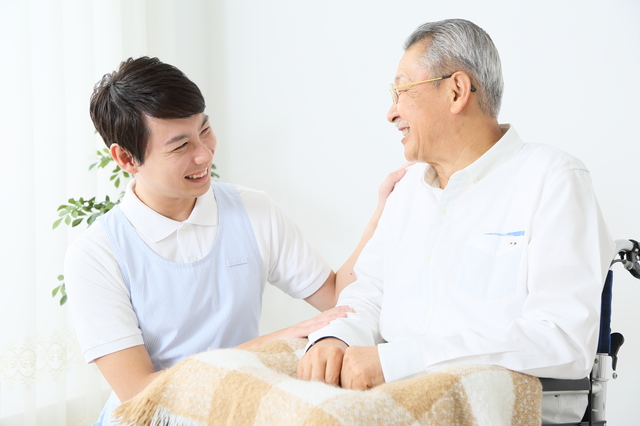 笑顔で利用者と話す男性介護職員