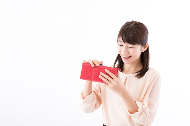 笑顔で財布を見る介護職の女性イメージ
