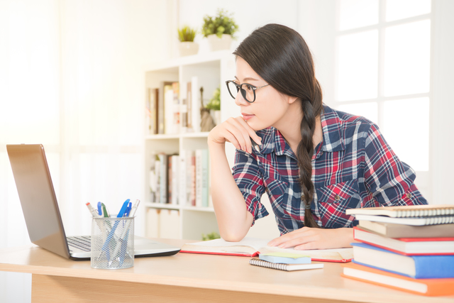 パソコンで勉強をする眼鏡の女性