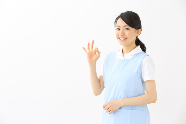 指で丸を作る介護職の女性
