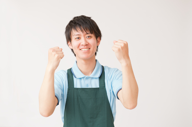 ガッツポーズをする介護職の男性